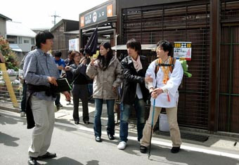 老舗うどん店「山越」で行われたロケ。本広克行監督(左端)と演技の打ち合わせをするユースケ・サンタマリア(右から2人目)と小西真奈美(同3人目)